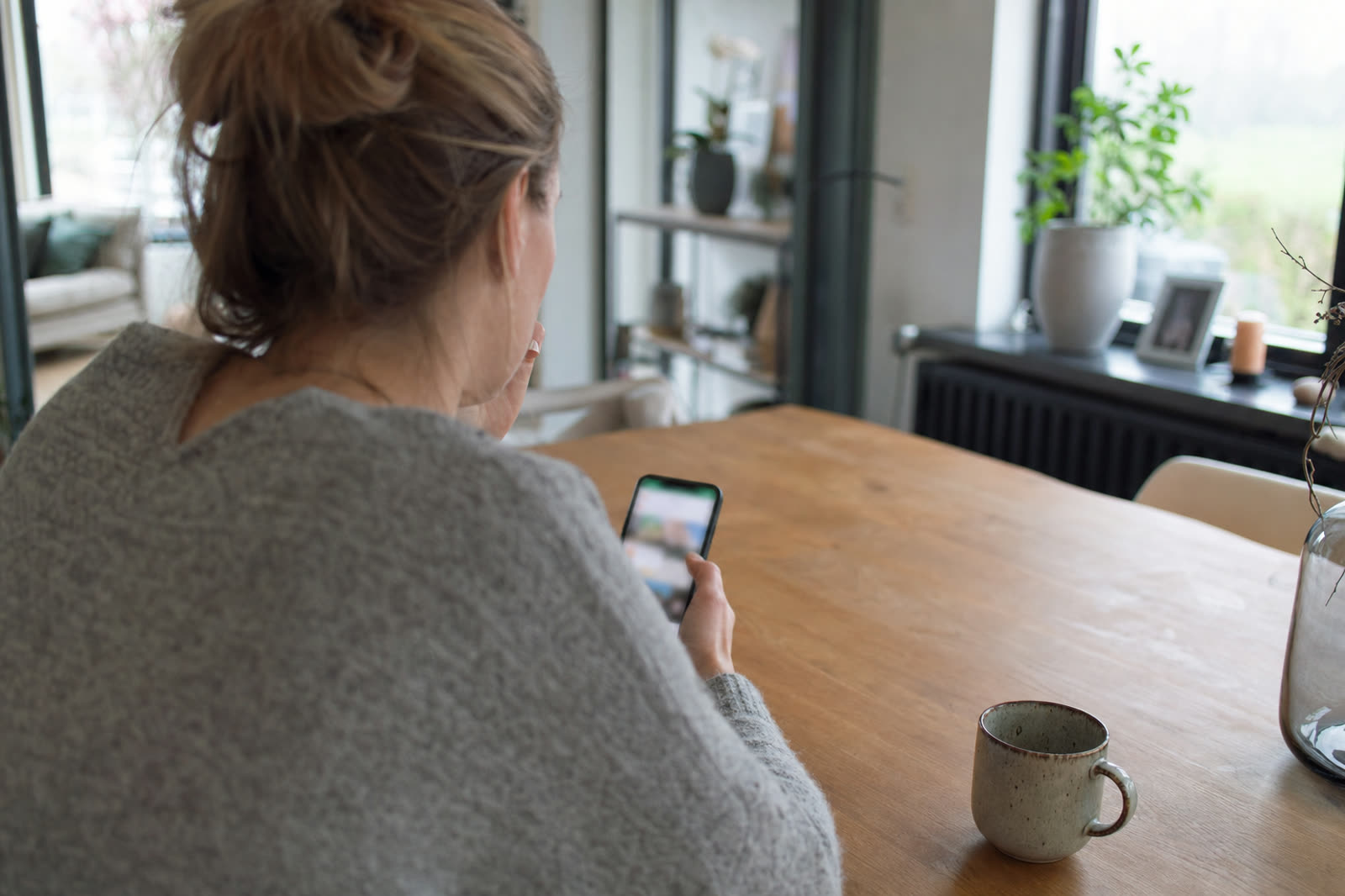 Huiseigenaar zoekt op de telefoon naar een vakman